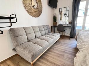 a couch in a room with a bed and a mirror at aeolian blu 1 in Parikia