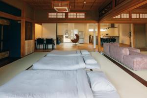 ein Zimmer mit einer Reihe Kissen auf dem Boden in der Unterkunft ゆたか in Kajiya
