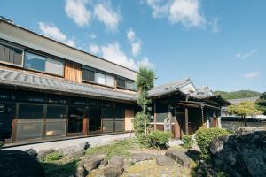 ein Gebäude mit einem Baum davor in der Unterkunft ゆたか in Kajiya