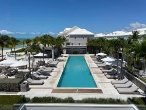 an aerial view of a resort swimming pool with chairs and umbrellas at White House - Exclusive Luxury Beachfront Villa - Private White Sand Beach in Nassau