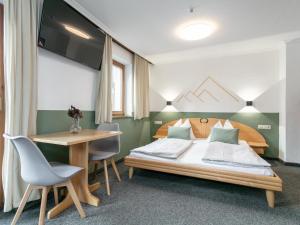 a bedroom with a bed and a table and chairs at Pension Schreder in Kirchberg in Tirol