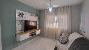 ein Schlafzimmer mit einem Bett und einem Flachbildfernseher in der Unterkunft Casa Marupiá - Natureza, simplicidade e bem-estar a poucos minutos do centro de Belém in Ananindeua