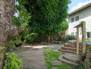 einen Garten mit einem Baum und ein paar Treppen in der Unterkunft Casa Marupiá - Natureza, simplicidade e bem-estar a poucos minutos do centro de Belém in Ananindeua