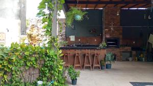 eine Küche mit einer Bar mit Stühlen und Pflanzen in der Unterkunft Casa Marupiá - Natureza, simplicidade e bem-estar a poucos minutos do centro de Belém in Ananindeua