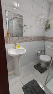 ein weißes Badezimmer mit Waschbecken und Toilette in der Unterkunft Casa Marupiá - Natureza, simplicidade e bem-estar a poucos minutos do centro de Belém in Ananindeua