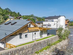 a house with a stone wall next to a river at Chalet Hornblick in Fieberbrunn