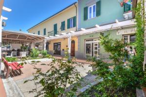a courtyard of a building with chairs and trees at Il Quadrifoglio 3 in Procchio