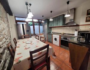 a kitchen with a table with chairs and a kitchen with a stove at El Camino in Molinaseca +9 photos