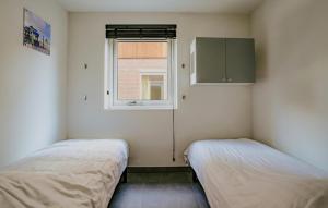 two beds in a small room with a window at Westergeest Luxe in Uitgeest