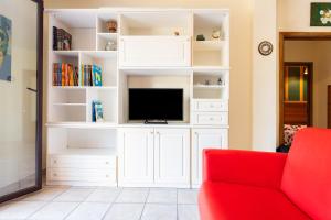 a living room with a red couch and a tv at Magy House in Quartu SantʼElena