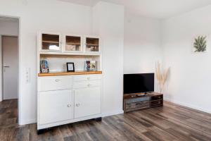 un salon avec une télévision et un mur blanc dans l'établissement Ferienwohnung am Bach, à Müllheim