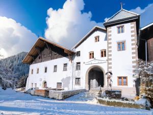 a large white building in the snow at Schloss Sissi in Pfunds