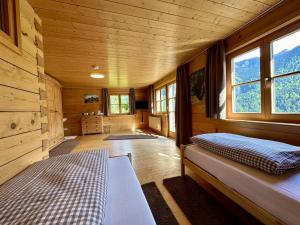 a room with a bed in a cabin with windows at Schwarzmann in Mellau