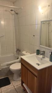 a bathroom with a sink and a toilet and a mirror at Casa centro de Villarrica in Villarrica