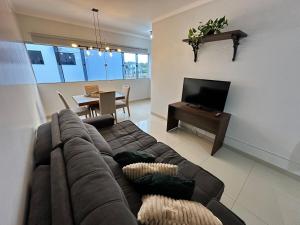 a living room with a couch and a dining room at Apto próx Hospital Regional até 6 pessoas com garagem e wifi in Nova Mutum