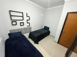 a bedroom with two beds and a wooden door at Apto próx Hospital Regional até 6 pessoas com garagem e wifi in Nova Mutum