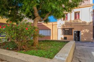 a tree in a garden next to a building at La casetta di Pietra in Sassari