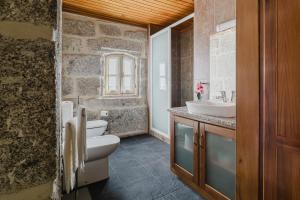 a bathroom with a white toilet and a sink at Cantinho da Tilde in Fafe +28 photos