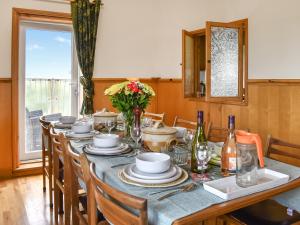 einen langen Tisch mit Stühlen, Teller und Blumen darauf in der Unterkunft The Boat House in Canterbury