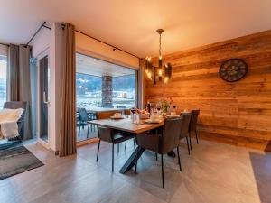une salle à manger avec une table, des chaises et une horloge dans l'établissement Mountain Chalet Aquarius 5B, à Sankt Lorenzen ob Murau