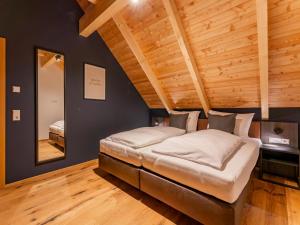 un lit dans une chambre avec un plafond en bois dans l'établissement Mountain Chalet Aquarius 5B, à Sankt Lorenzen ob Murau