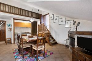 クールマイヨールにあるCasa Mountain View Courmayeurのテーブルとテレビのあるダイニングルーム