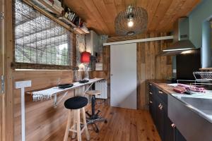 a kitchen with wood paneling and a counter with a stool at Cabanon Belle Lune in Arrien-en-Bethmale