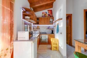 a kitchen with wooden cabinets and a microwave at Samarighouse in Putzu Idu