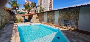 a swimming pool in front of a building at Pousada House Beach 2 - BRASIL - Aviação in Praia Grande