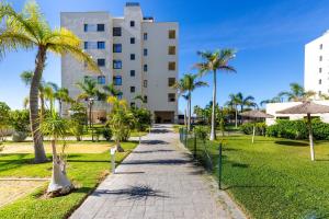 a walkway in front of a building with palm trees at Apartamento Playa Marinsa in Torre del Mar