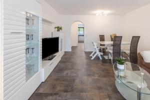 ein Wohnzimmer mit einem TV und einem Esszimmer in der Unterkunft Heidis Dihei in Büsingen