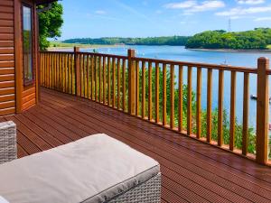 a wooden deck with a view of the water at Badger Lodge in Burton