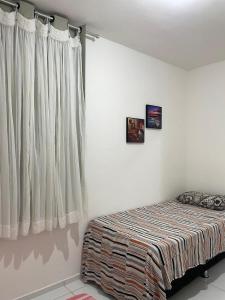 een slaapkamer met een bed en een raam bij Park Barra Mais Viver in Barra dos Coqueiros +3 foto's