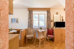 Una cocina y un comedor con mesa y sillas. en Figisterhof, en Chiusa