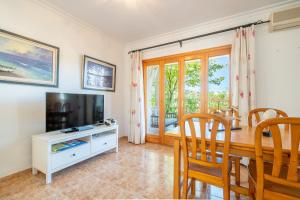 a living room with a dining room table and a television at Que Bo in Alcudia