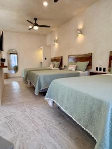 a bedroom with two beds and a ceiling fan at CASA VICTORIA in Chichén-Itzá +54 photos