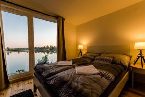 1 dormitorio con cama y ventana grande en Sun City Vízisport Paradicsom en Hódmezővásárhely