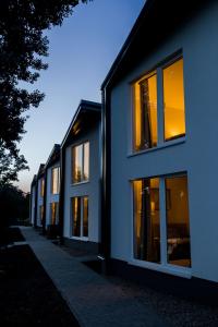 una fila de casas con ventanas iluminadas al atardecer en Sun City Vízisport Paradicsom en Hódmezővásárhely