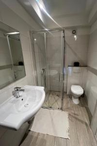 a bathroom with a shower and a sink and a toilet at Apartments by the sea Novigrad - 24877 in Novigrad Istria +17 photos