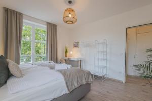 a bedroom with a large white bed and a window at Rentaflat Hamburg 01 am Bahnhof in Norderstedt