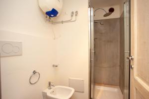 a bathroom with a shower and a toilet and a sink at Hora Est in Orosei