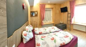 a small bedroom with a bed and a television at Casa Sara in Pozza di Fassa