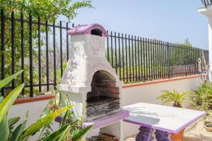 a stone oven in front of a fence at Mini appartamento in Villa in Noto