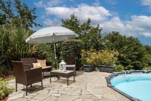 a patio with chairs and an umbrella next to a pool at Casa vacanze I Prati in Sorano