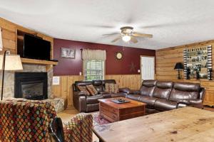 a living room with leather furniture and a fireplace at Sundance Cabin with Hot Tub and WiFi in Slade