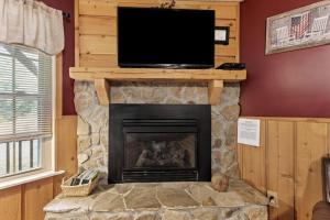 a fireplace with a flat screen tv on top of it at Sundance Cabin with Hot Tub and WiFi in Slade
