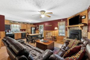a living room with a leather couch and a fireplace at Sundance Cabin with Hot Tub and WiFi in Slade
