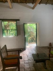 a room with a table and a bench and two windows at Casa Victoria in Piedecuesta