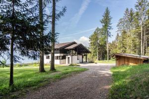 a house in the woods with a gravel road at Chalet Marianna in Meltina +15 photos