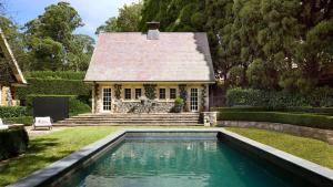 a house with a swimming pool in front of a house at Hazelwood House in Mittagong